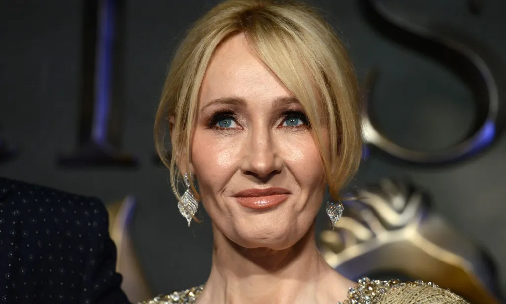 L'auteur de Harry Potter, JK Rowling, regarde quelque part hors caméra tout en portant une robe dorée et des bijoux assortis.