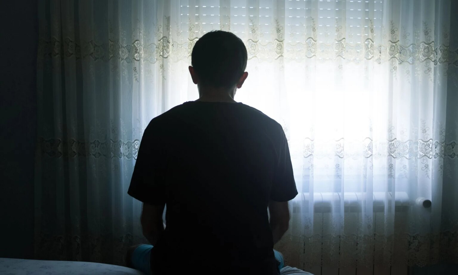 Une adolescente trans « tente une auto-mastectomie » en attendant une intervention chirurgicale dans un « acte de désespoir » The back of a person looking out a window.