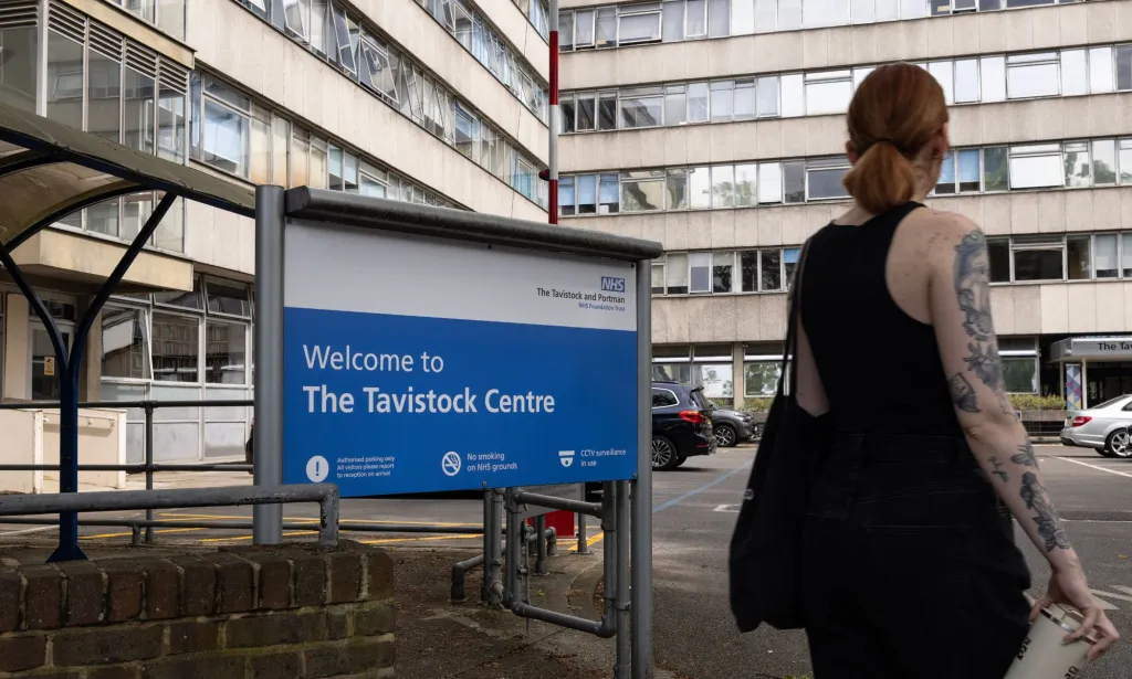 Une personne passant devant le panneau du Tavistock Center.