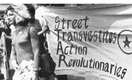 Sylvia Rivera with a Street Transvestite Action Revolutionaries banner.