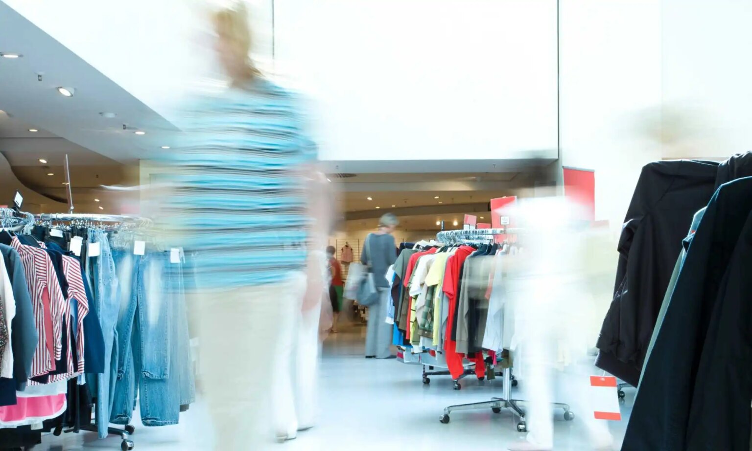 La France va-t-elle interdire la fast fashion ? Blurred customer in a clothing store.