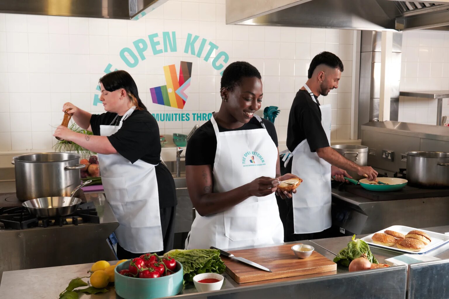 Deliveroo ouvre un restaurant éphémère LGBTQ+ pour aider les futurs chefs queer – et vous pouvez commander sa nourriture This is an image of three people preparing food in a kitchen