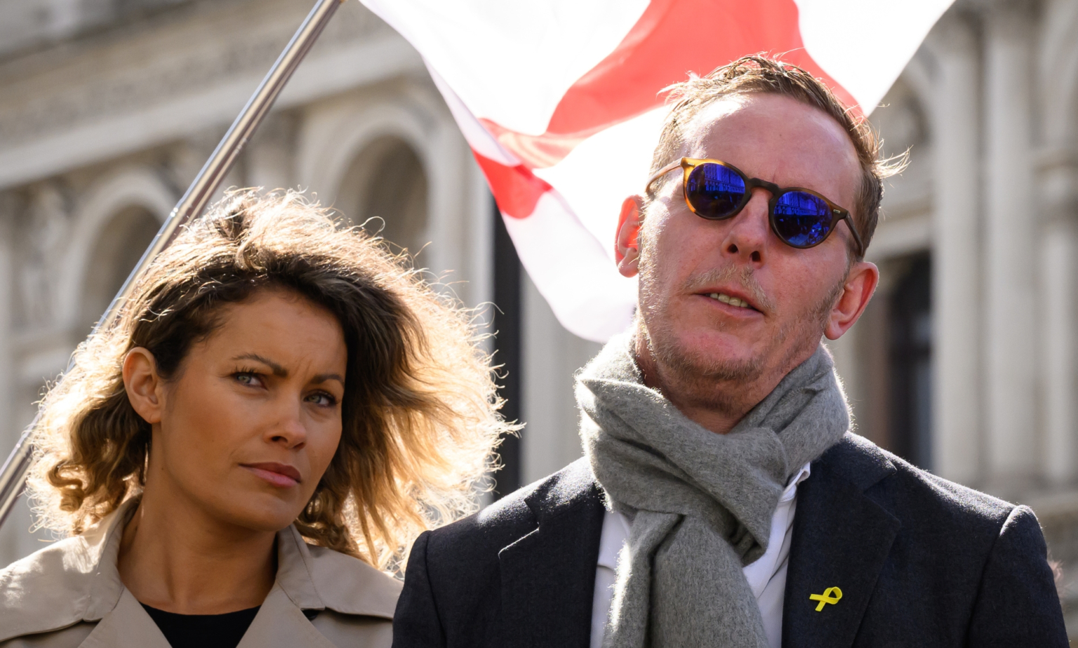 Laurence Fox a annoncé qu'il était fiancé… à un collègue théoricien du complot and Laurence Fox are standing together with an England flag blowing behind them