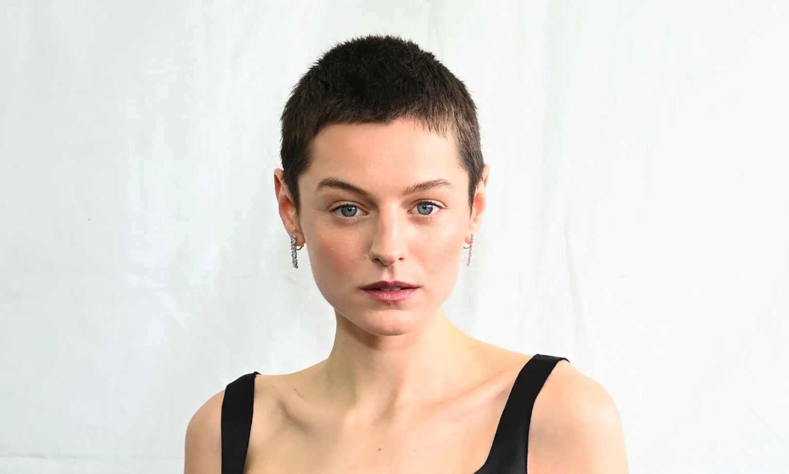 Emma Corrin, de Deadpool et Wolverine, se sent mal à l'aise parce qu'elle s'identifie comme non binaire Emma Corrin with cropped brown hair and wearing a strapped black dress at the 2024 Film Independent Spirit Awards.