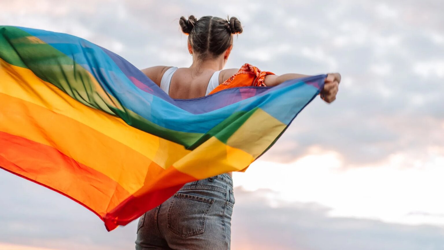La Californie interdit aux districts scolaires de révéler l'identité LGBTQ+ de leurs enfants à leurs parents Girl stands holding an LGBTQ+ flag behind her back