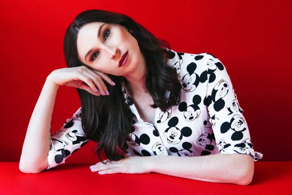 Juno Dawson inclinant la tête avec un fond rouge.