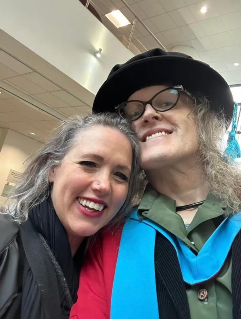 Addy dans une robe de remise de diplôme avec sa femme Leea.
