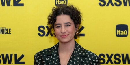Ilana Glazer in a spotted dress against a yellow background