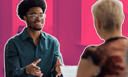 This is an image of a job interview. There is a Black man with glasses speaking to a white women with blond hair.