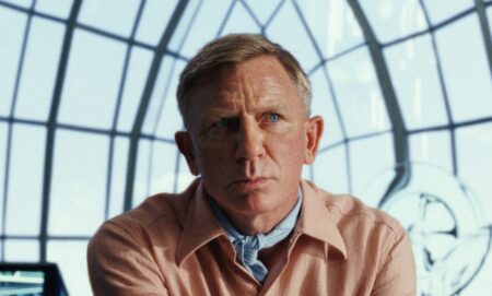 Daniel Craig in a peach suit against a window