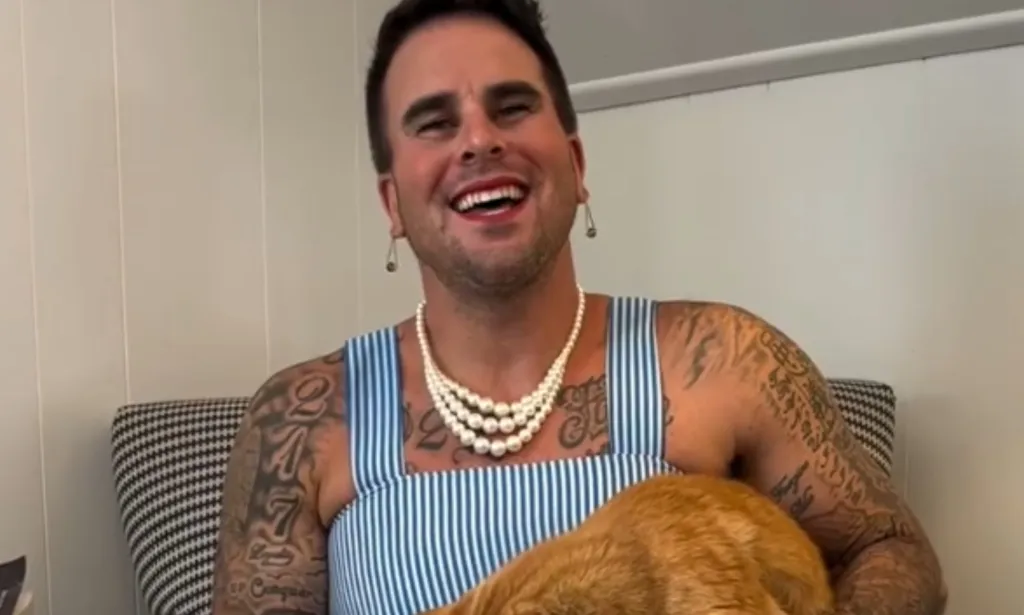 Josh Seiter dans une robe tenant un chat.
