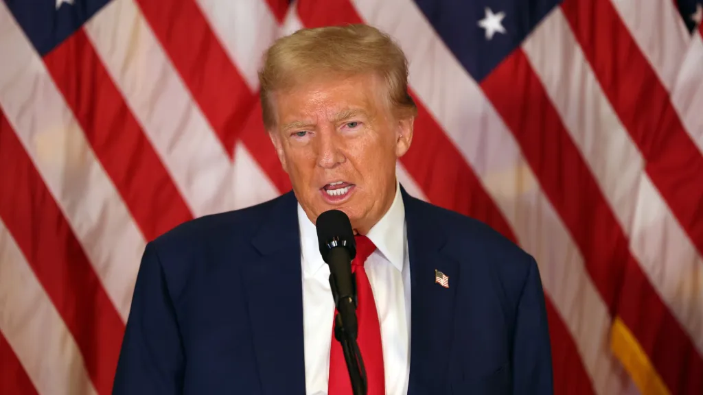 Photo de Donald Trump debout devant un drapeau américain