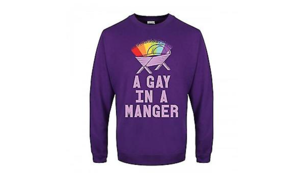 Debenhams contraint de retirer le pull de Noël « A Gay In A Manger » après une réaction violente A purple Christmas jumper with a rainbow over a crib and the text 'a gay in a manger' from Debenhams