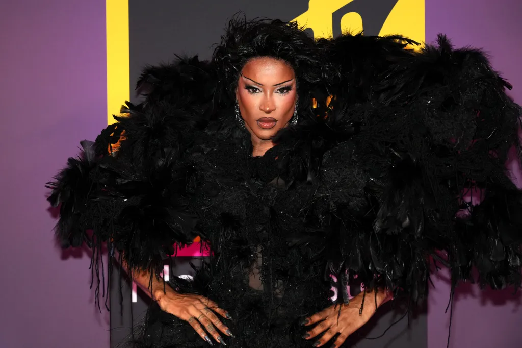 Tayce assiste aux MTV EMA 2024. Vêtue d'une grande épaule à plumes noires.