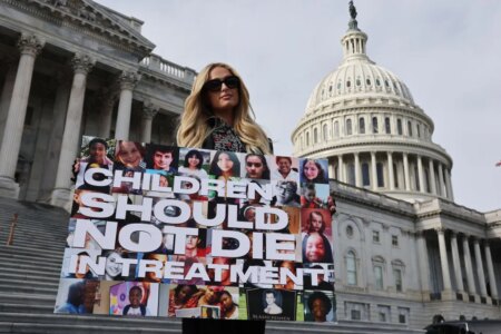 Paris Hilton holding a sign saying
