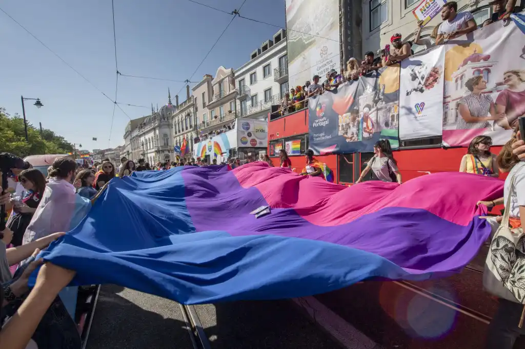 Les participants affichent un drapeau de la fierté bisexuelle lors d'un défilé de la fierté en 2019 à Lisbonne, au Portugal