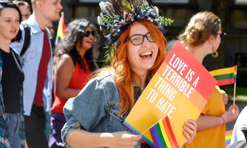 Un militant LGBTQ+ tient une pancarte disant 