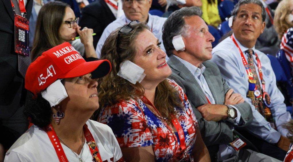 MILWAUKEE, WISCONSIN - 17 JUILLET : Les gens portent "bandages" à leurs oreilles alors qu'ils regardent le troisième jour de la Convention nationale républicaine au Fiserv Forum le 17 juillet 2024 à Milwaukee, Wisconsin. Des délégués, des hommes politiques et des fidèles républicains sont à Milwaukee pour la convention annuelle, qui se termine par l'acceptation par l'ancien président Donald Trump de la nomination présidentielle de son parti. Le RNC a lieu du 15 au 18 juillet. (Photo de Joe Raedle/Getty Images)