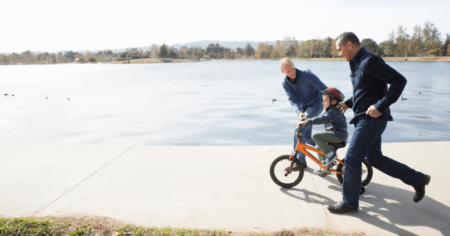 Un couple gay apprend à son enfant à faire du vélo.