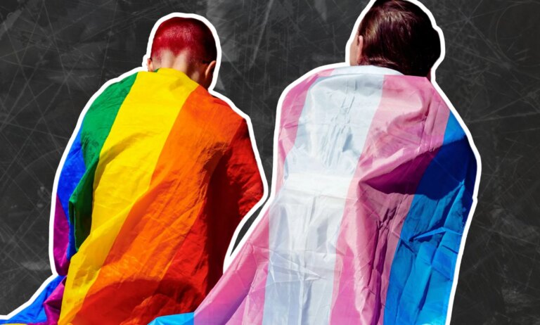 Two activists wearing Pride flags as capes.