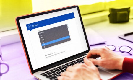 A laptop with a customer form on the screen and the gender-neutral title