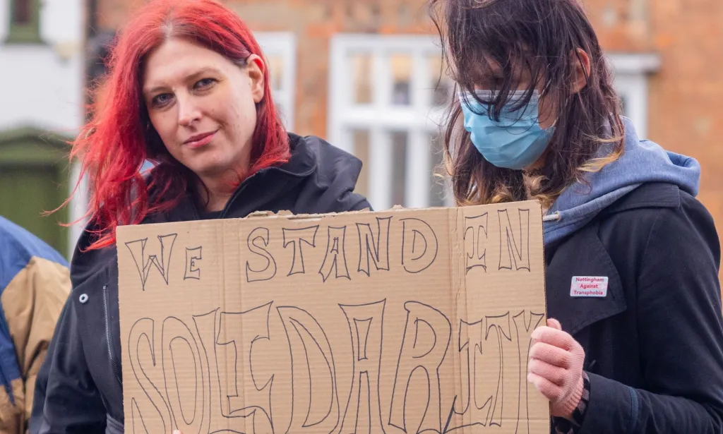 Deux manifestants brandissent une pancarte indiquant « Nous sommes solidaires »