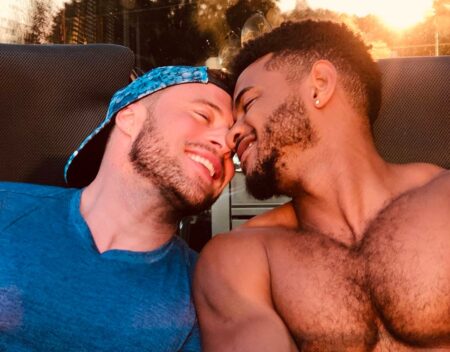 Duncan James and a topless Rodrigo Reiss smiling and cuddling