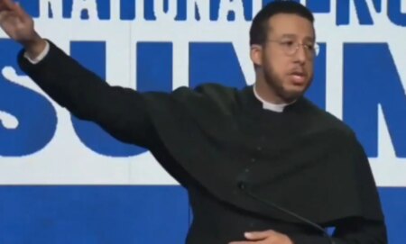 Calvin Robinson making a salute during a speech.