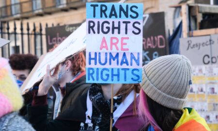 A trans rights supporter holds up a sign reading "Trans Rights are Human Rights" during a protest against the UK Goverment Section 35 stopping Scotland