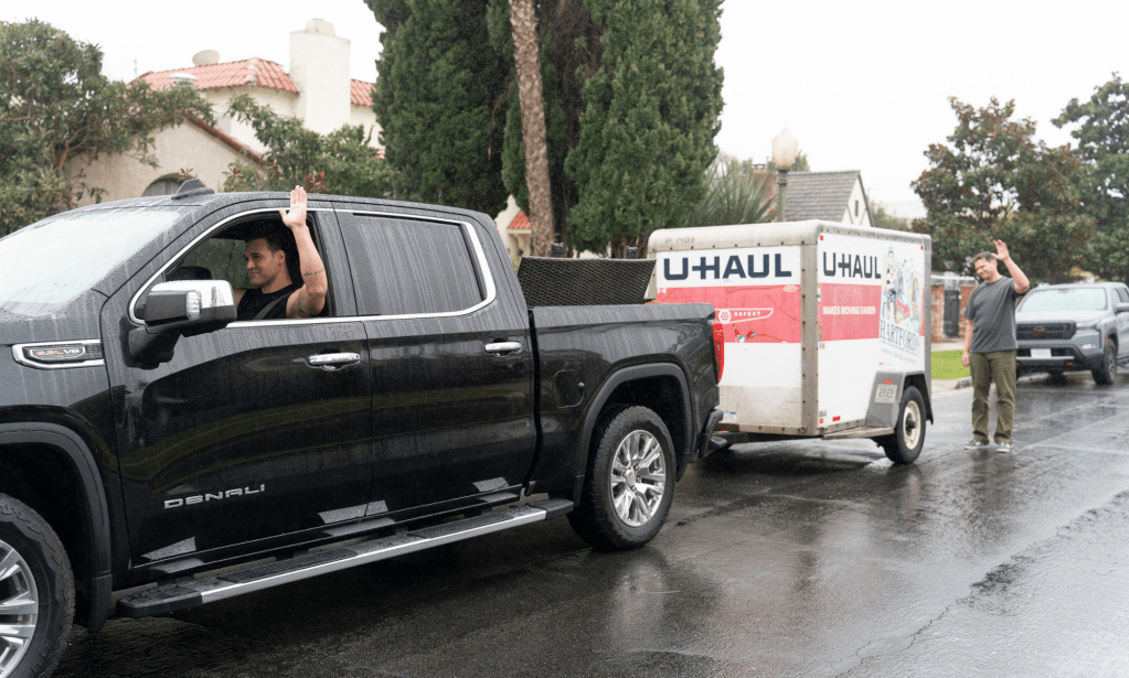 Eddie conduisant avec un U-Haul et laissant Buck derrière.