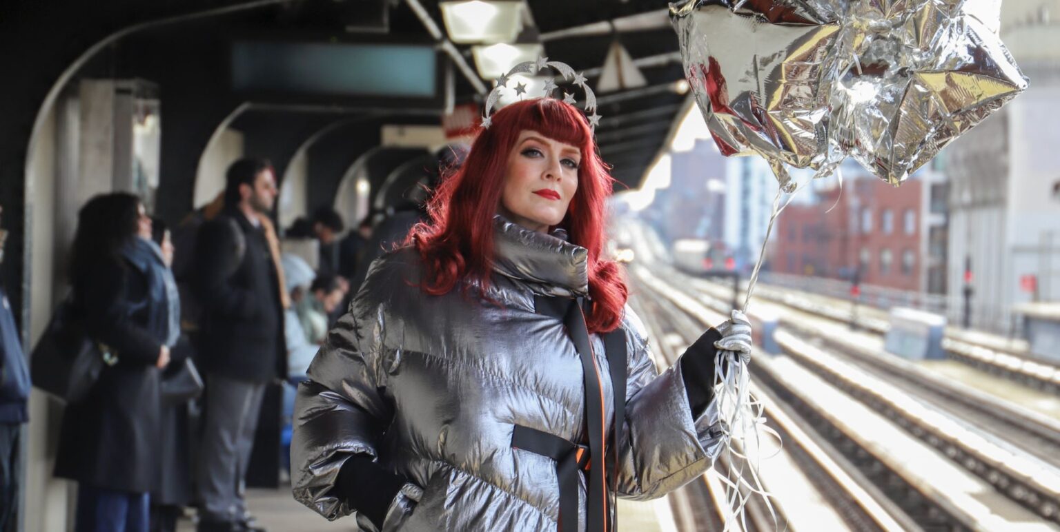 Ana Matronic at a train station holding a balloon
