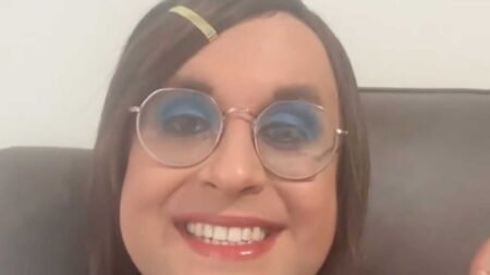 Trans teacher Rosie Sandri smiles widely at the camera.