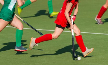 People playing with hockey sticks.