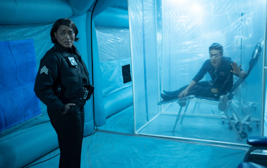 Athena et Chim dans une tente. Athena regarde hors caméra et le cheminée est assis sur une chaise en se rétablissant.