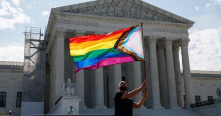 WASHINGTON, DC - 26 juin: Supporter du mariage homosexuel Vin Testa, de Washington, DC, Waves Un drapeau de la fierté LGBTQIA devant le bâtiment de la Cour suprême des États-Unis alors qu'il fait des photos avec son ami Donte Gonzalez pour célébrer les Deciscisions du 26 juin, 2023 à Windsor et à Washington, DC. Aujourd'hui marque le 8e anniversaire de la décision de la Cour suprême dans l'affaire Obergefell c. Hodges qui a garanti le droit au mariage pour les couples de même sexe.