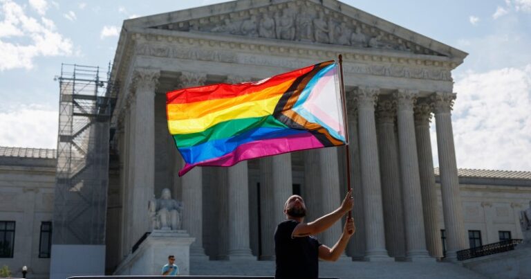 WASHINGTON, DC - 26 juin: Supporter du mariage homosexuel Vin Testa, de Washington, DC, Waves Un drapeau de la fierté LGBTQIA devant le bâtiment de la Cour suprême des États-Unis alors qu'il fait des photos avec son ami Donte Gonzalez pour célébrer les Deciscisions du 26 juin, 2023 à Windsor et à Washington, DC. Aujourd'hui marque le 8e anniversaire de la décision de la Cour suprême dans l'affaire Obergefell c. Hodges qui a garanti le droit au mariage pour les couples de même sexe.