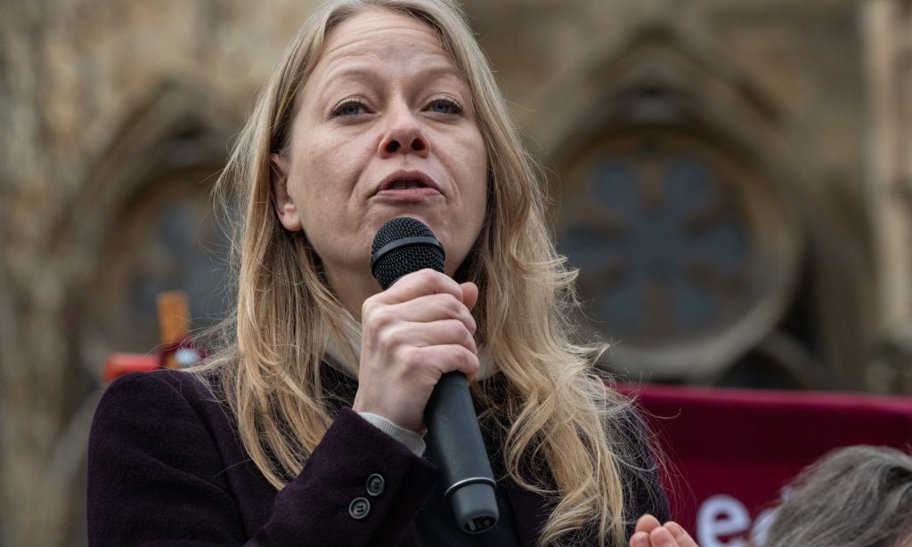 MP des Verts Sian Berry illustré tenant un microphone.