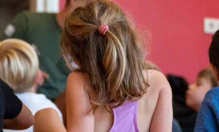 The back of a toddler in a class.
