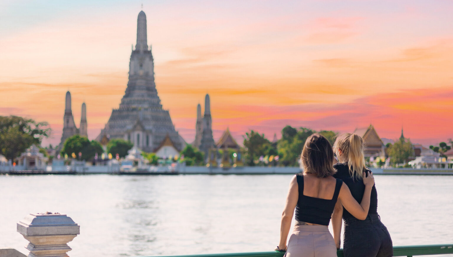 Two women discover Bangkok riding a boat in Chao Phraya river looking out from the boat