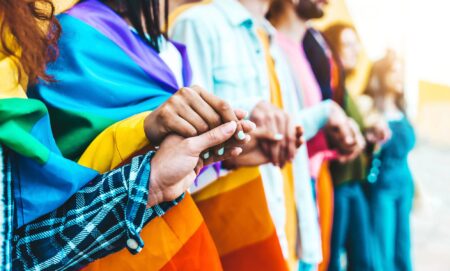 A group of LGBTQ+ teens holding hands.