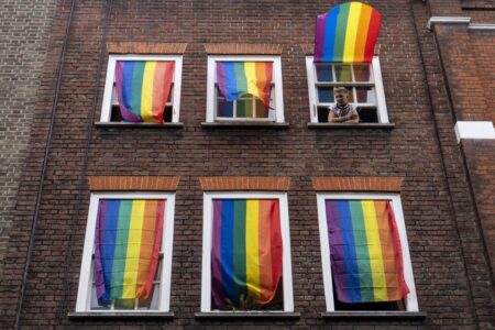 Rainbow flags cover a set of windows in Soho at Pride in London in 2019.