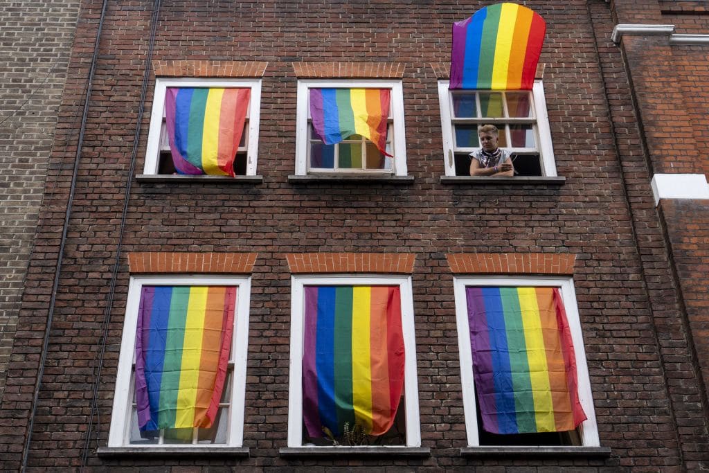 Rainbow flags cover a set of windows in Soho at Pride in London in 2019.