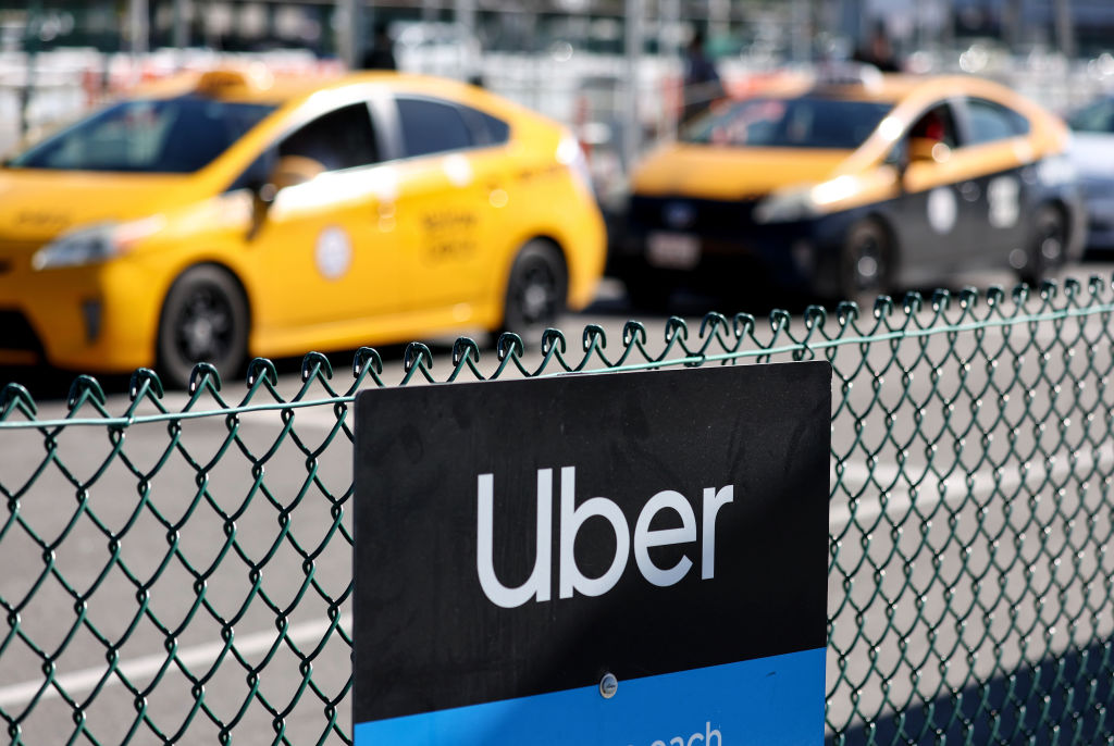An image of two yellow taxi cabs with the uber logo in the foreground