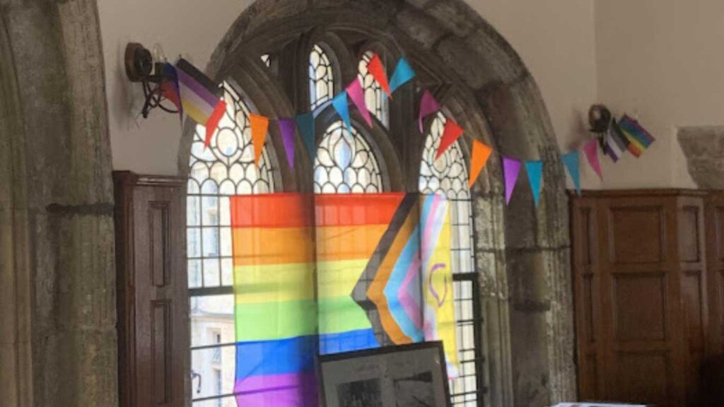 Pride flag across the window of an Oxford college.