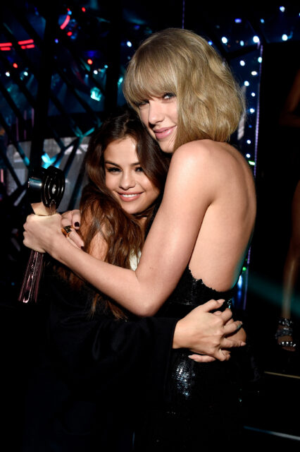 La chanteuse Taylor Swift (R), lauréate du prix de l'album de l'année pour '1989' ', embrasse l'actrice / chanteuse Selena Gomez dans les coulisses des Iheartradio Music Awards qui ont diffusé en direct sur TBS, TNT et Trutv du forum le 3 avril 2016 à Inglewood, en Californie.