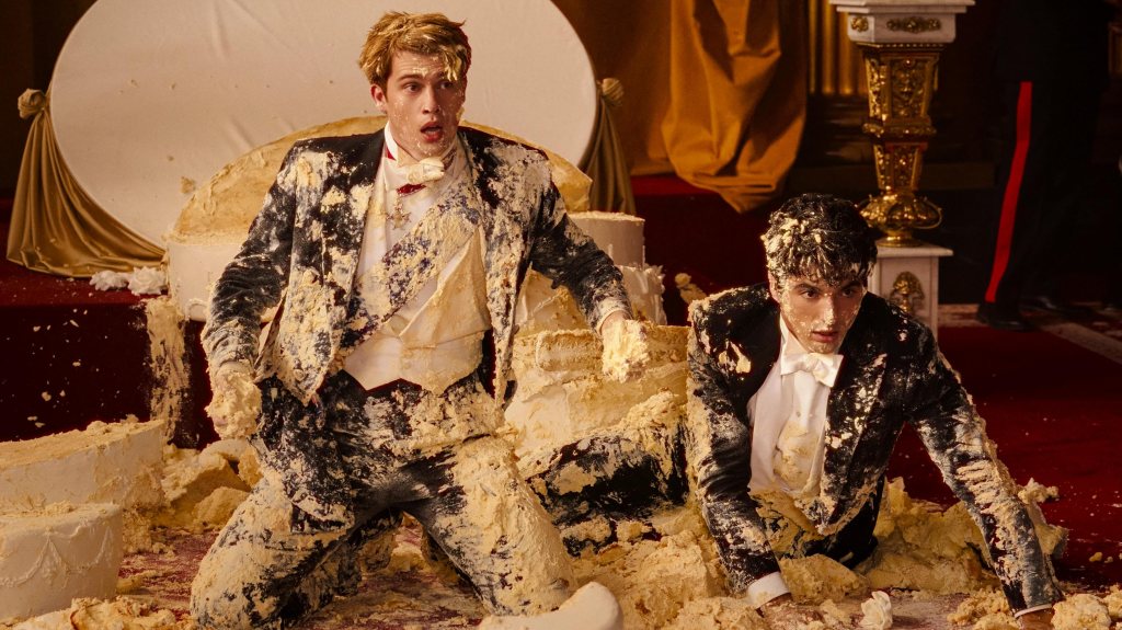 Rouge, blanc et bleu royal Still: Alex (Perez) et le prince Henry (galitzine) sur le sol recouvert de gâteau et de glaçage après que un gâteau de la tour royale se soit effondré dessus.