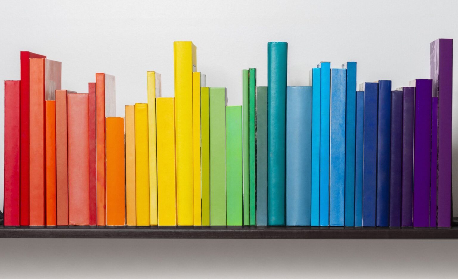 Multicoloured books on bookshelf.