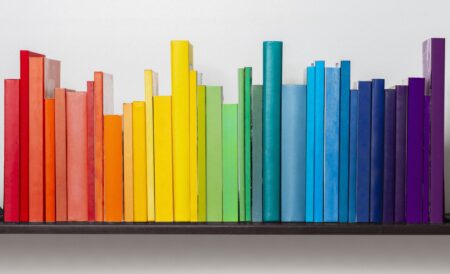 Multicoloured books on bookshelf.