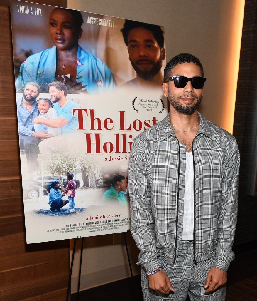 Jussie Smollett assiste à la première à Atlanta de "The Lost Holliday. Il se tient devant l'affiche du film I Na Na Gris Suit et les lunettes de soleil noires.