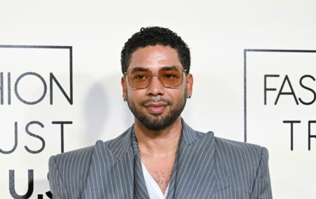 Jussie Smollett in a grey pinstruoe suit. He